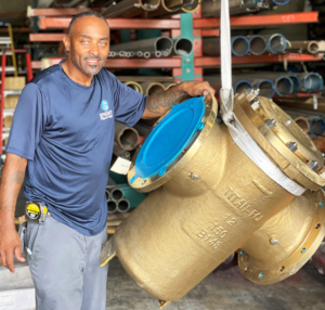 This picture is of an Energy Pipe & Supply employee standing next to a large Titan basket strainer.