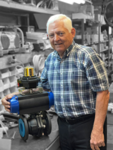 This picture is of Klar Rovira, the founder of Energy Pipe & Supply, holding an actuator valve